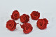 A box of six large preserved roses in a garnet red hue that are wide open