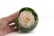 A round bowl containing a preserved peach rose set on preserved green hydrangea.