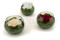 A round bowl containing a preserved peach rose set on preserved green hydrangea.