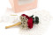 A romantic boutonniere in vibrant red tones, made with preserved flowers and foliage