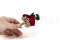 A romantic boutonniere in vibrant red tones, made with preserved flowers and foliage