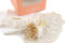 A boutonniere for a special occasion in white and cream tones, made with preserved flowers and foliage.