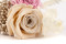 A boutonniere for a special occasion in pale pink and beige tones, made with preserved flowers and foliage.