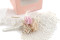 A boutonniere for a special occasion in pale pink and beige tones, made with preserved flowers and foliage.
