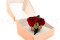 A romantic boutonniere in vibrant red tones, made with preserved flowers and foliage